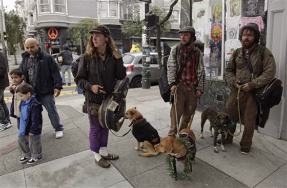 From right, Joe Lust, 20, of Austin, Tex., Steven Grossman, 21, of Fort Collins, Colo., and Liz Mallion, 22, of Hawaii stand with their dogs on April 20 at the corner of Haight and Ashbury streets in San Francisco. A year after a controversial prohibition against sitting or lying on sidewalks was proposed, police have begun enforcing the law along the city's most famous stretches of streets. But renewed squabbling has broken out between those who say the law is working and those who say it is unenforceable and unfairly targets the homeless. 